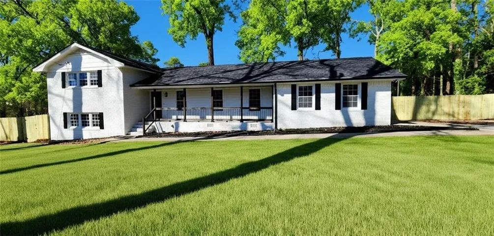 White exterior with black shutters and a covered front porch featuring black railings