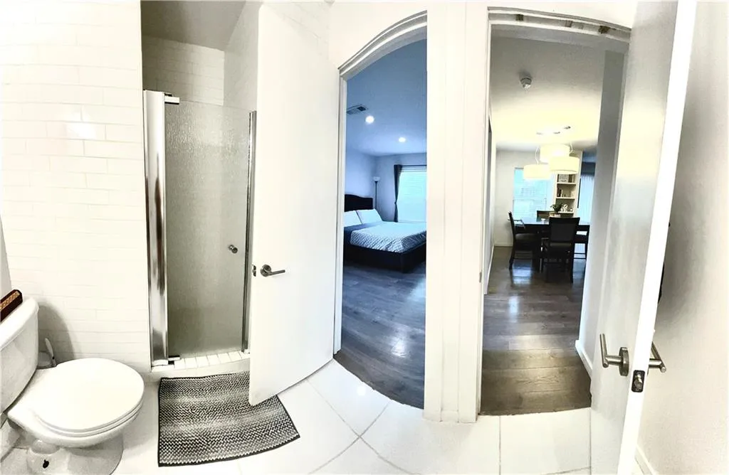Jack and jill style bathroom featuring walk in shower, toilet, and tile floors. Entry way from bedroom or common area to preserve bedroom privacy.