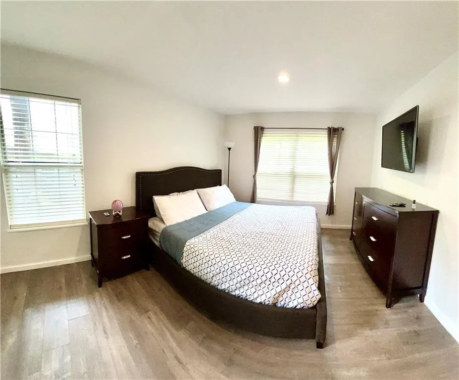 Bedroom featuring hardwood / wood-style floors and multiple windows