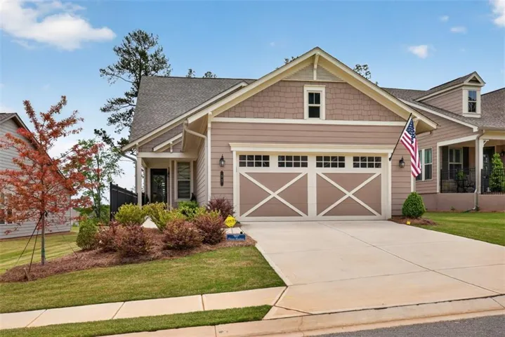 Single-story residence featuring a two-car garage with decorative doors and transom windows