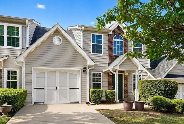 Siding exterior with brick accents and a gabled roofline