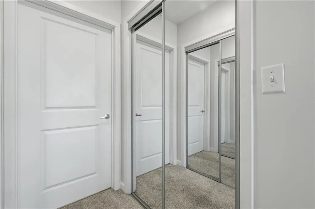 Mirrored closet doors and paneled interior doors with brushed nickel hardware