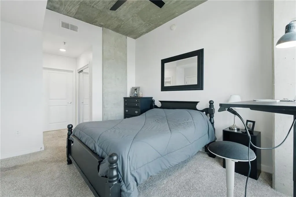 Concrete ceiling, concrete structural column, light-colored carpeting, white walls, and a recessed light fixture