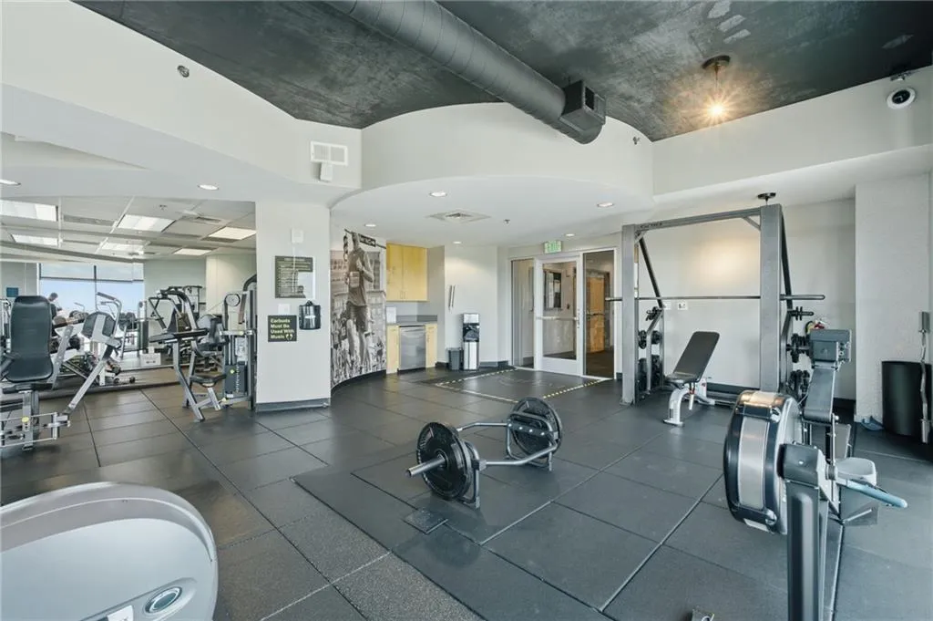 Fitness center with rubber flooring, recessed lighting, and exposed ductwork