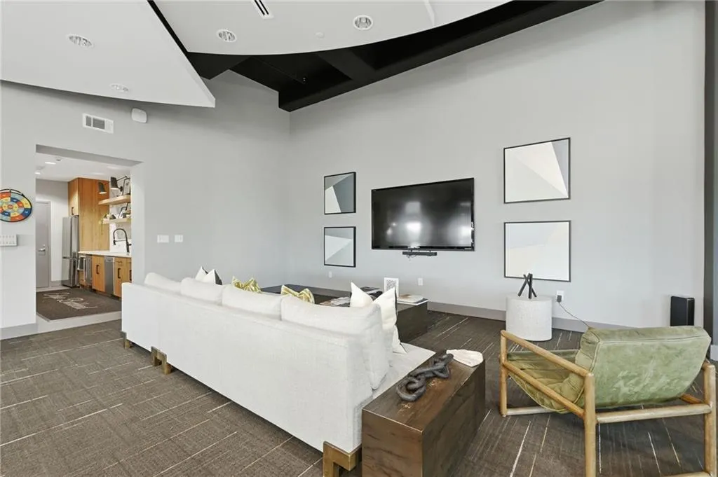Open concept living area with contemporary gray walls, recessed lighting, and a mounted flat-screen television