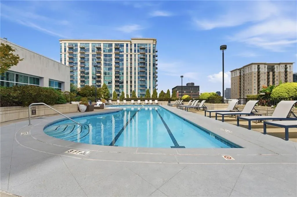 Outdoor swimming pool with integrated spa, surrounded by a hardscape deck