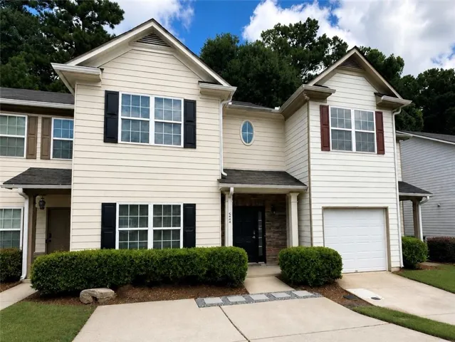 Two-story exterior with light-colored siding, contrasting shutters, and a prominent front entry