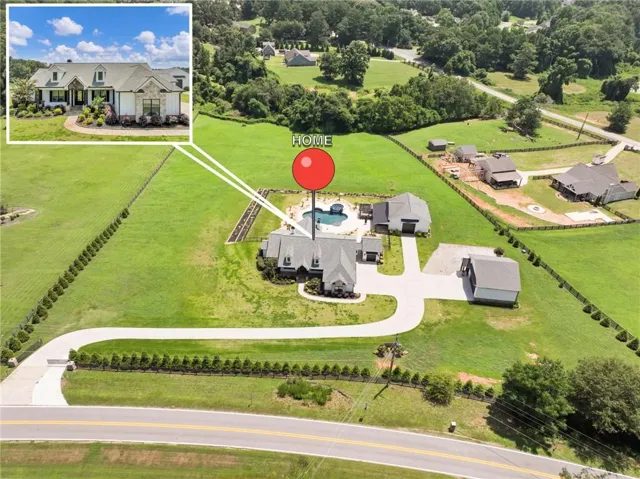 Expansive property featuring a circular driveway, an in-ground swimming pool, and multiple outbuildings
