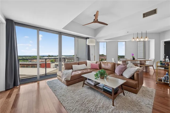 Sun-filled living and dining areas anchored by expansive windows and skyline views