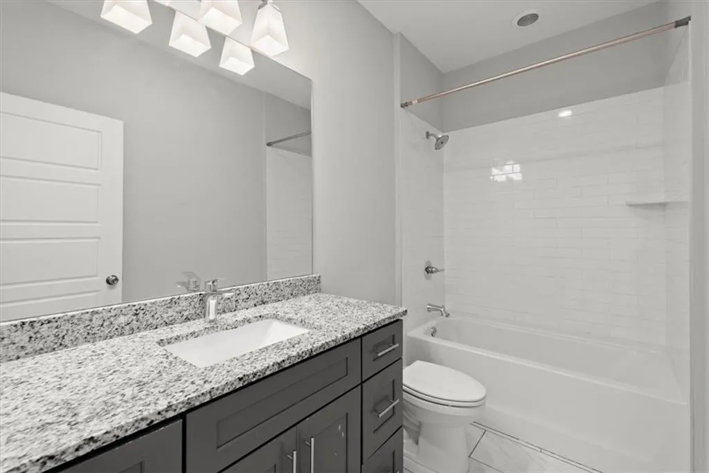 Full bathroom with washtub / shower combination and vanity
