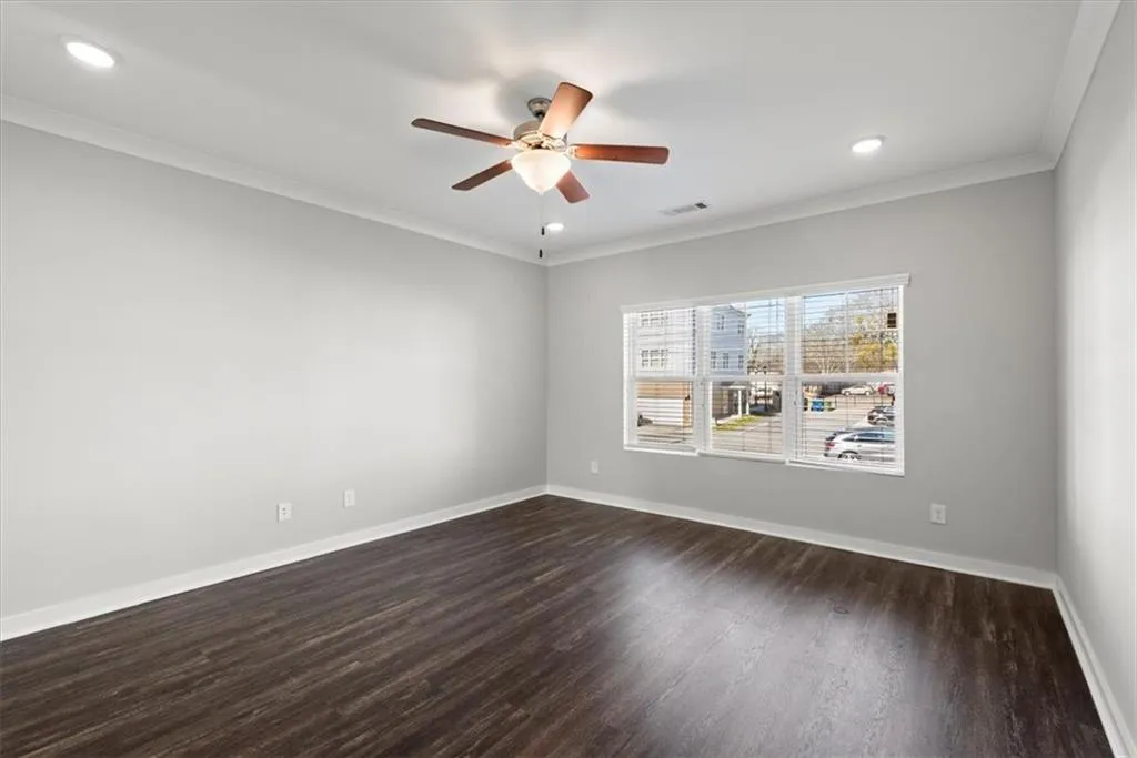 Spare room featuring crown molding, dark wood finished floors, recessed lighting, and ceiling fan