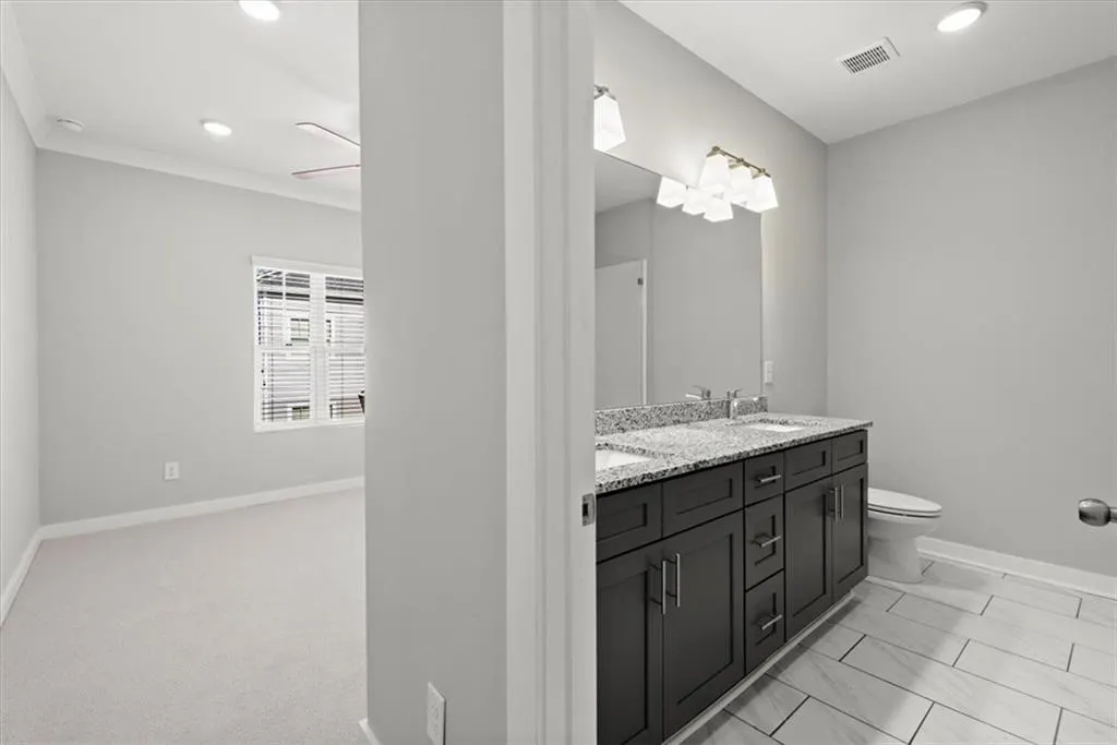 Full bathroom with double vanity and recessed lighting