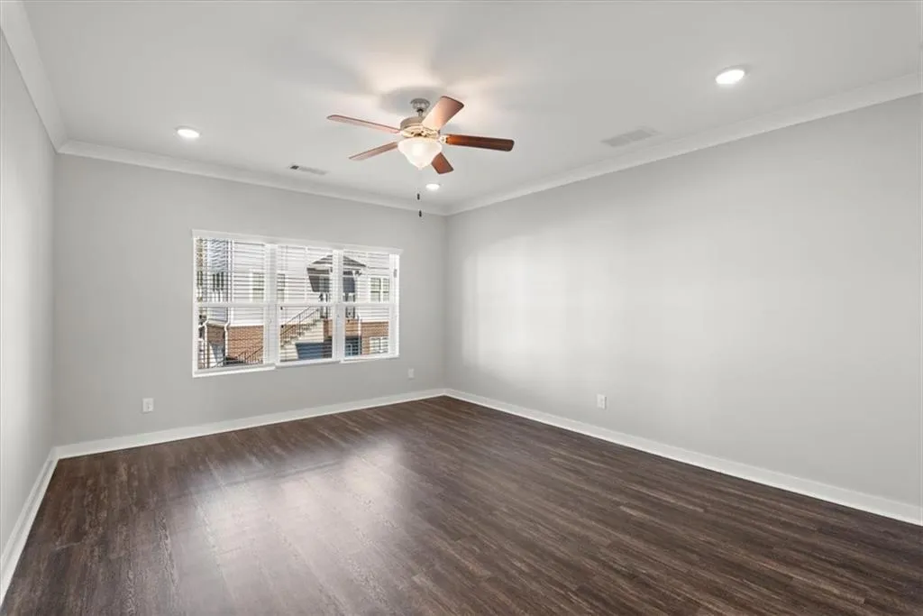 Spare room featuring crown molding, dark wood-style floors, ceiling fan, and recessed lighting