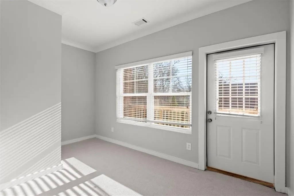 Spare room with light carpet and baseboards
