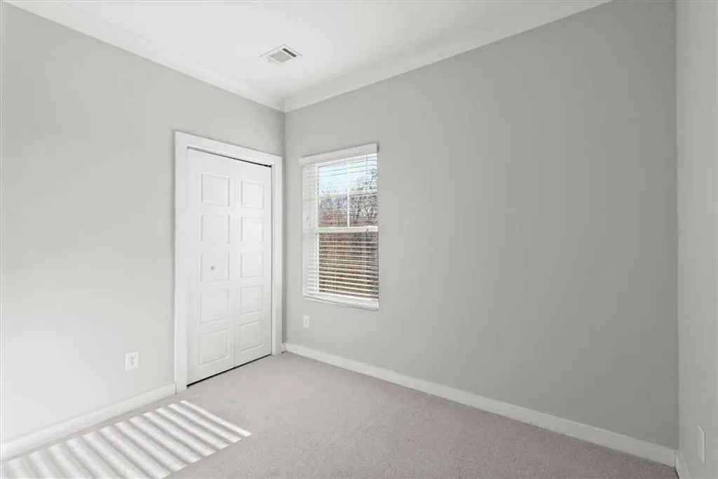 Unfurnished bedroom with carpet floors, ornamental molding, and a closet