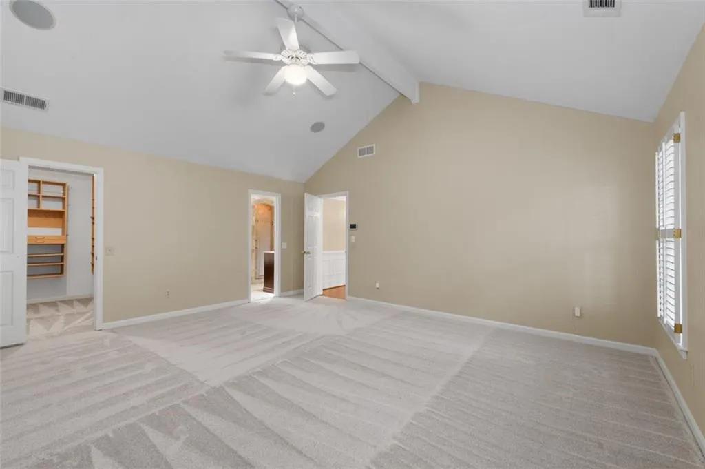 Vaulted primary bedroom has new carpet & paint