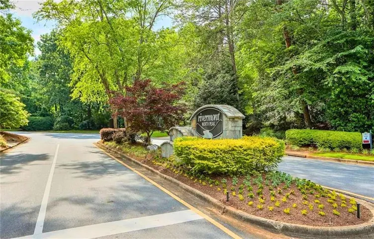 View of asphalt road featuring curbs and view of scattered trees
