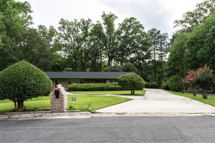 Ranch-style residence featuring a dark shingle roof and light-colored siding