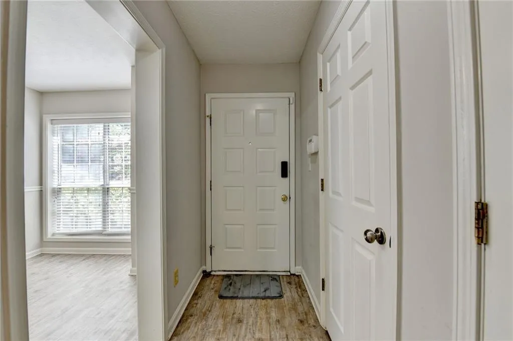 Doorway featuring light wood-type flooring and baseboards