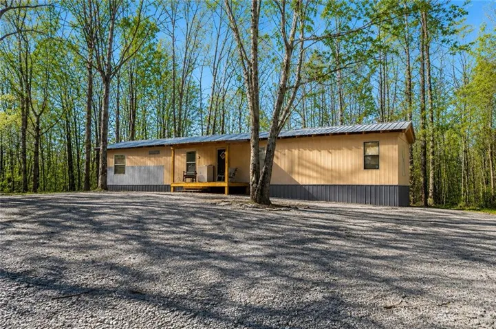 Single-story residence featuring wood-tone panel siding and a metal roof