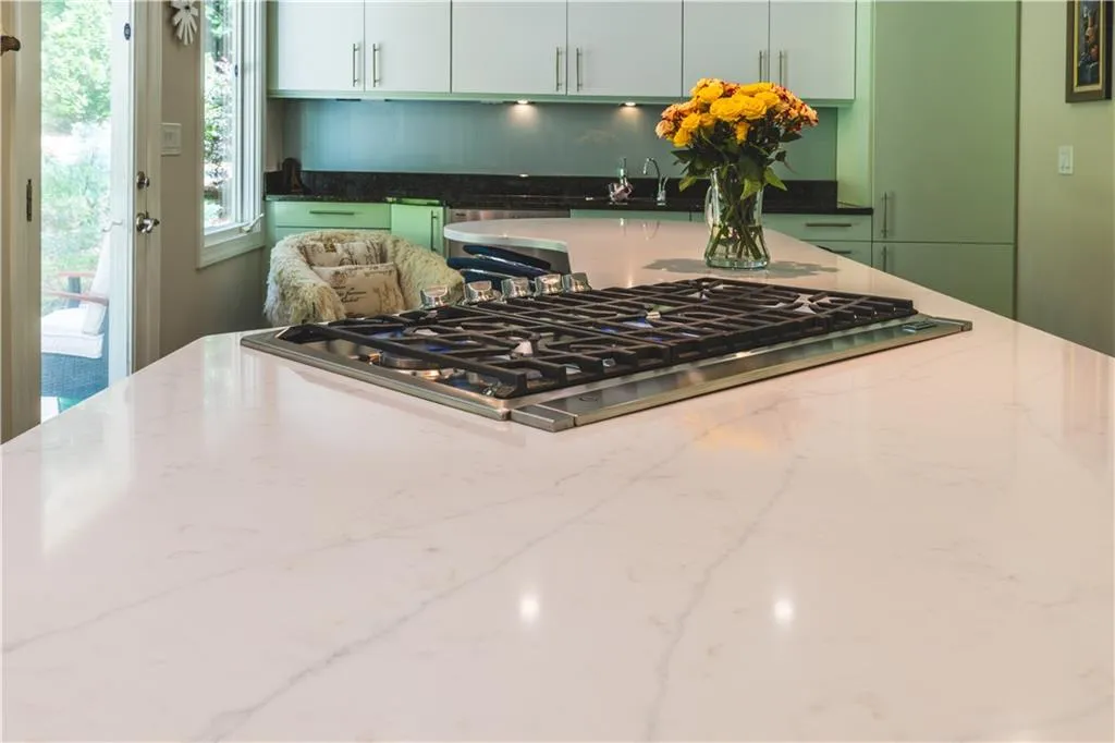 Kitchen featuring stainless steel gas stovetop and light stone counters