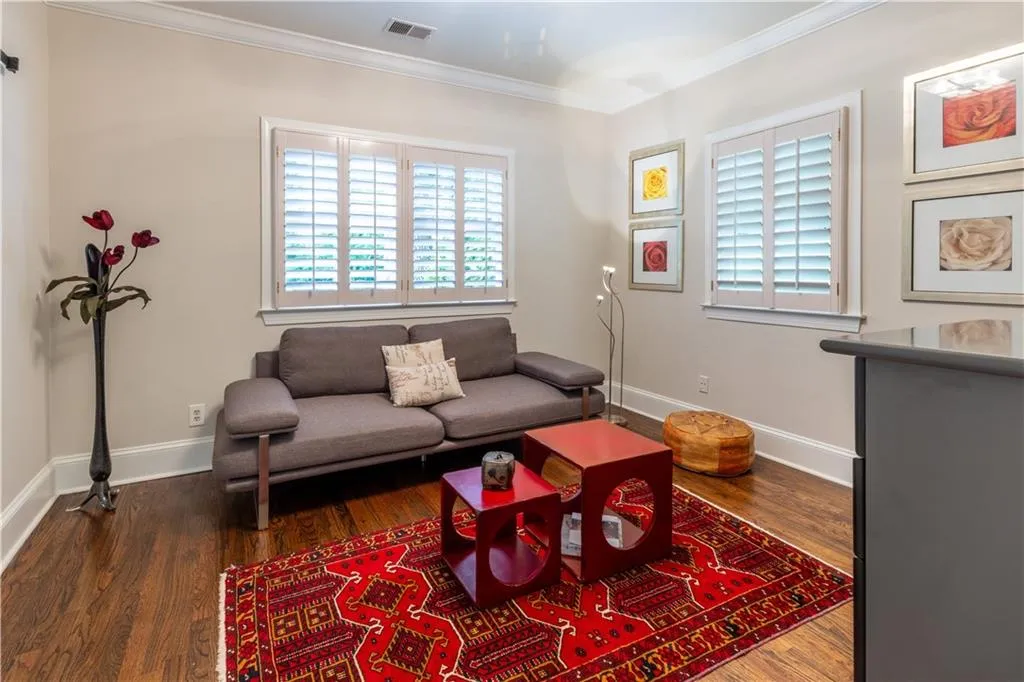 Living room with ornamental molding, wood finished floors, and baseboards
