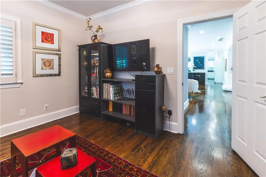 Living room featuring wood finished floors, crown molding, and baseboards