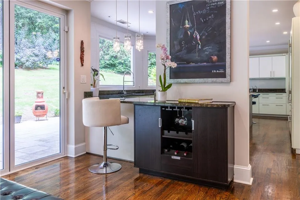 Bar with ornamental molding, dark wood finished floors, a sink, baseboards, and recessed lighting