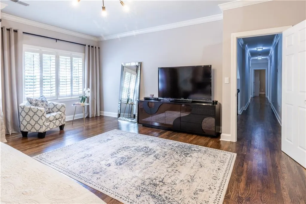 Living area with ornamental molding, dark wood finished floors, and baseboards