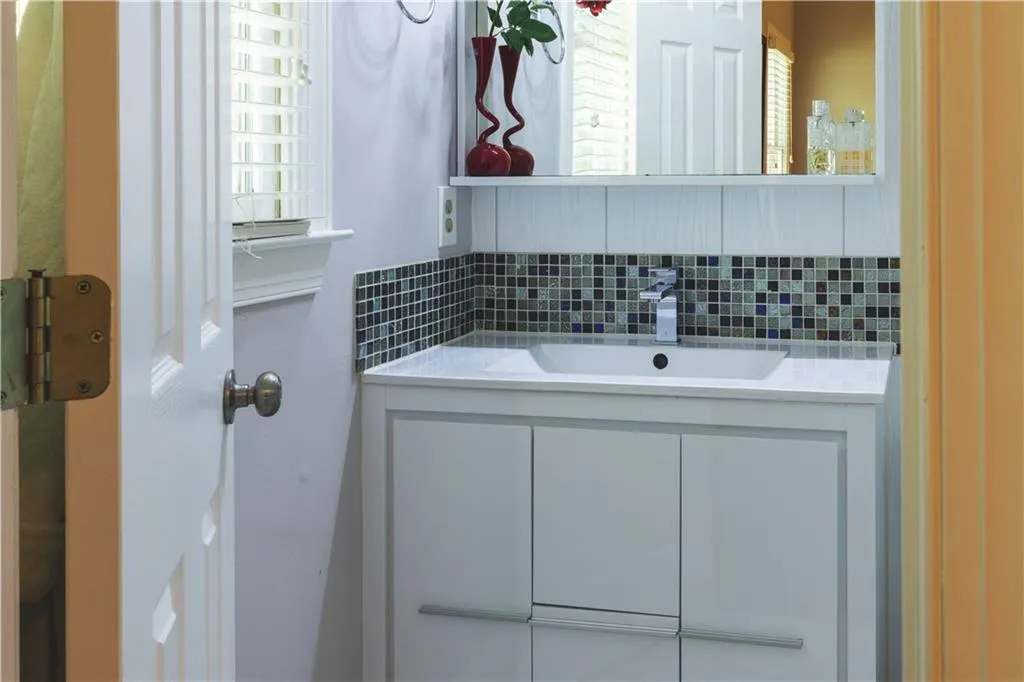Bathroom featuring vanity, tasteful backsplash, and plenty of natural light