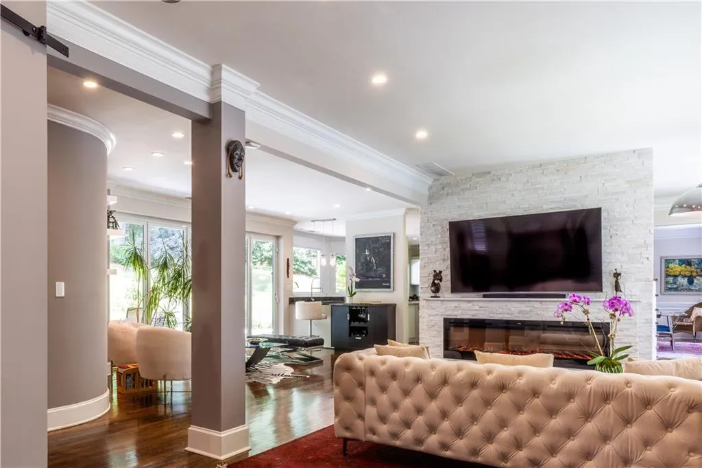 Living area with ornamental molding, wood finished floors, baseboards, and recessed lighting