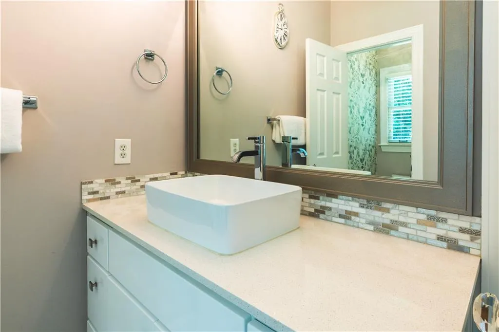 Bathroom with vanity and decorative backsplash