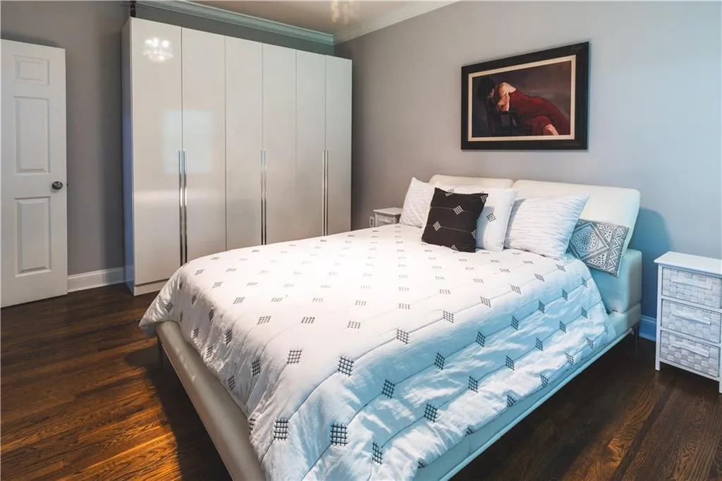 Bedroom featuring crown molding, dark wood finished floors, and baseboards
