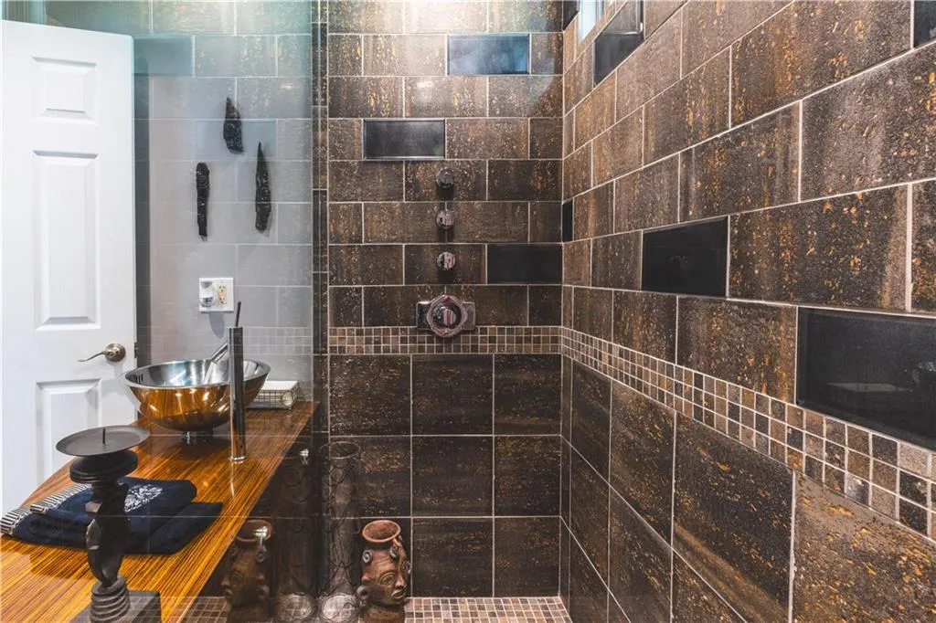 Full bath with a tile shower and tile walls