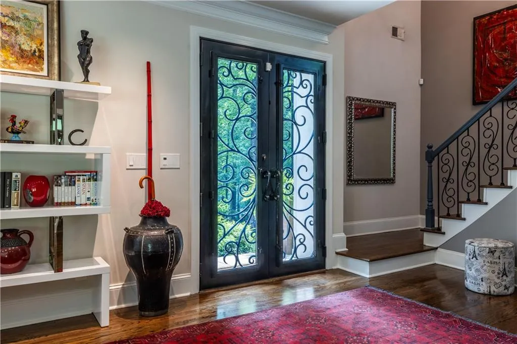 Entryway with french doors, wood finished floors, stairs, baseboards, and ornamental molding
