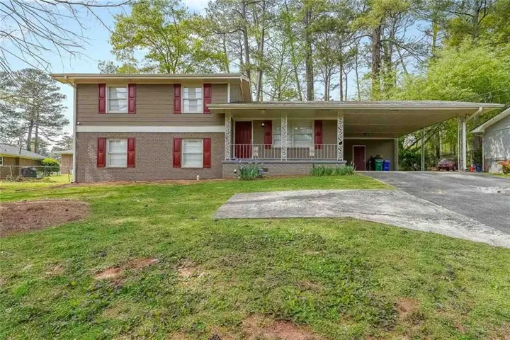 Two-story exterior with a covered front porch and a carport