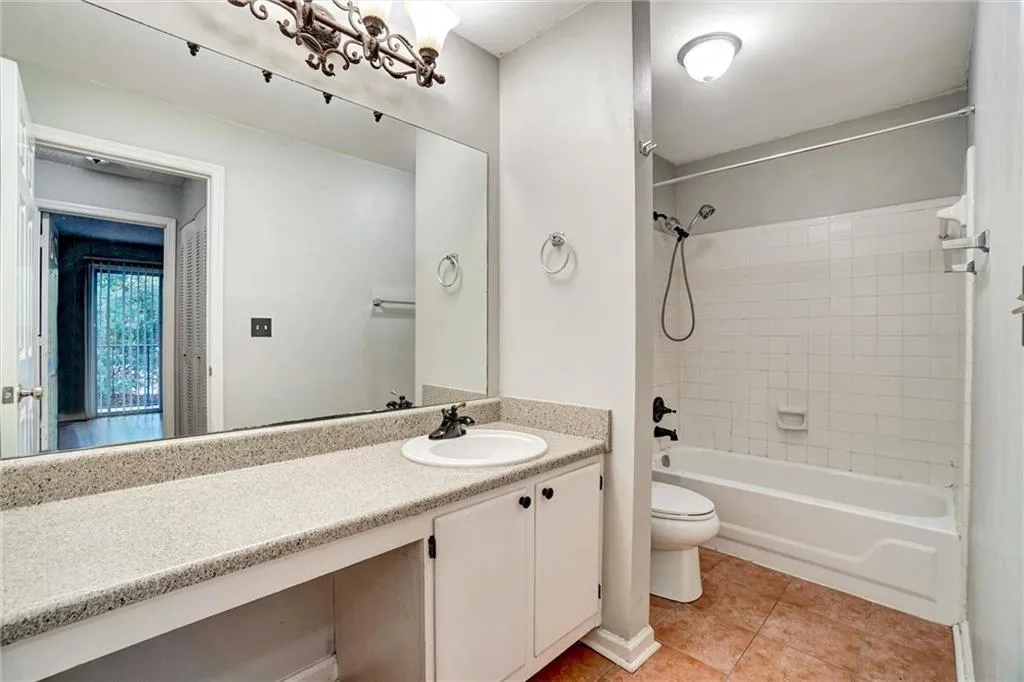 Bathroom featuring shower / washtub combination, vanity, and light tile patterned floors
