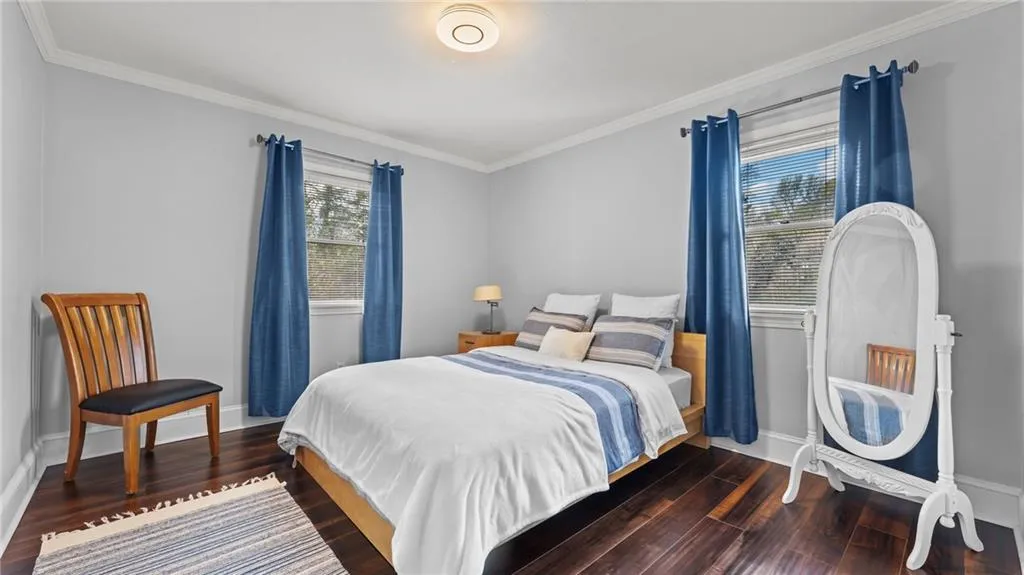 Bedroom with dark wood finished floors and ornamental molding