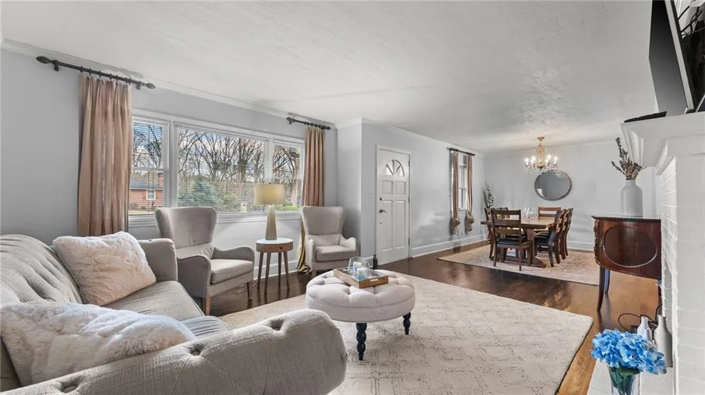 Living area featuring dark wood-style flooring, hanging lights, and crown molding