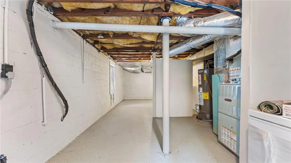 Unfinished basement featuring water heater and heating unit