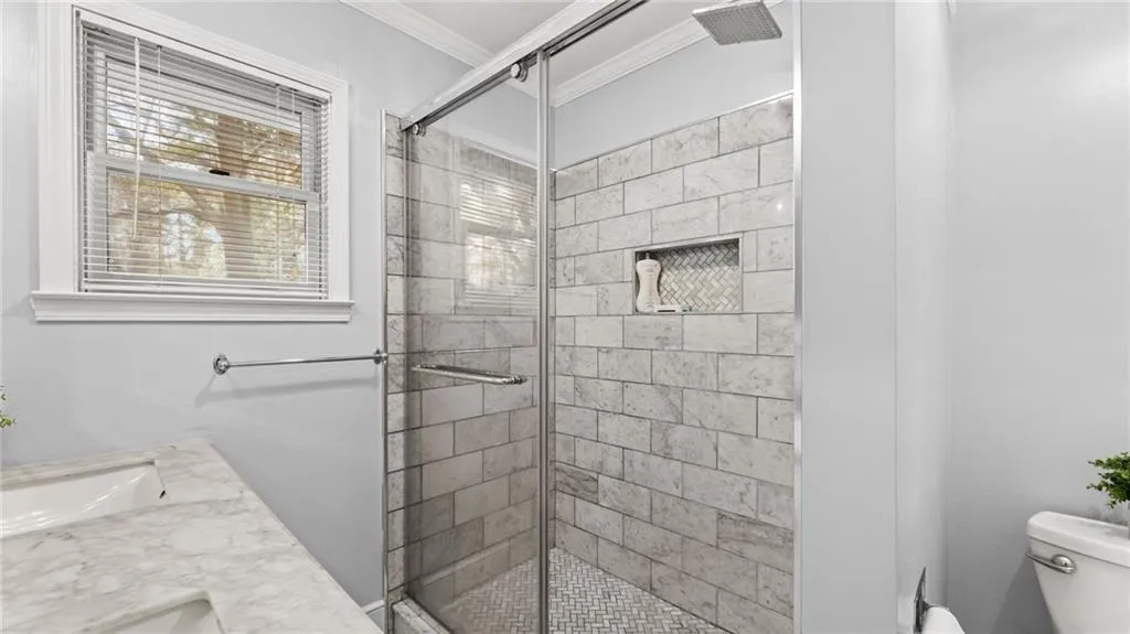 Full bathroom featuring ornamental molding, a shower stall, and vanity