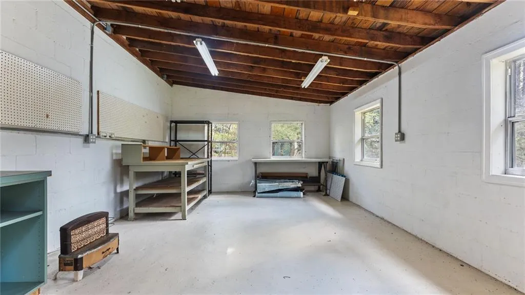 Below grade area with concrete block wall and wooden ceiling