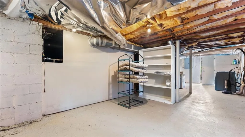 Unfinished below grade area with washer / clothes dryer and electric panel