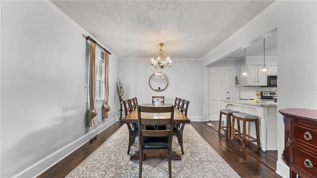 Dining space featuring a chandelier, dark wood-type flooring, and ornamental molding