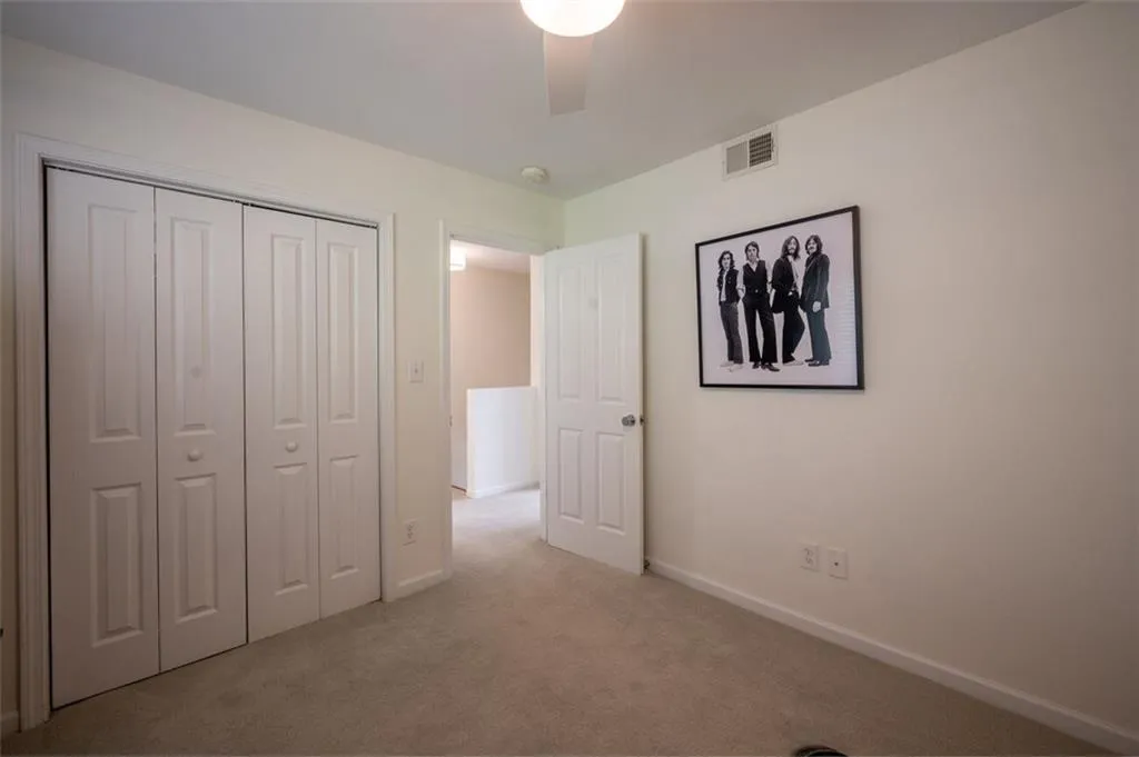 Unfurnished bedroom with carpet flooring, a closet, and a ceiling fan