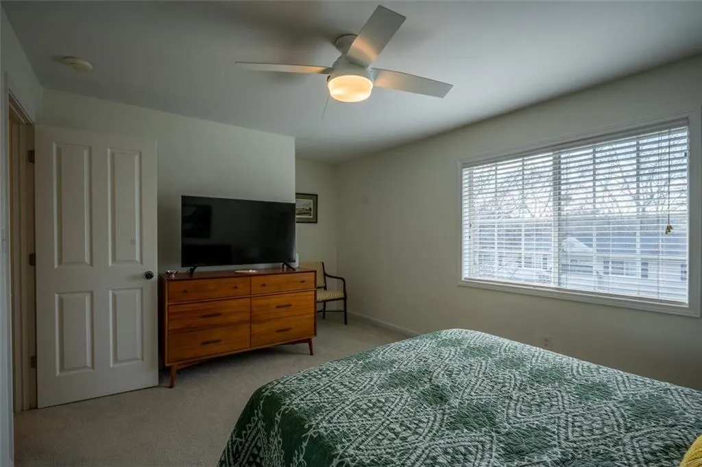 Bedroom featuring light carpet and a ceiling fan