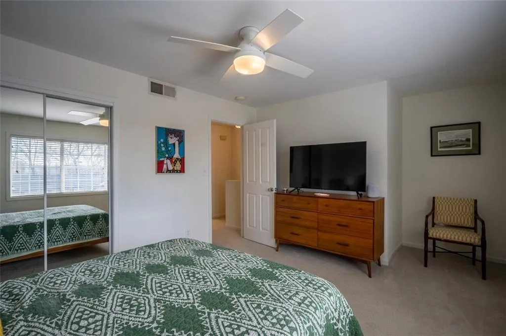 Bedroom with light carpet, a closet, and ceiling fan