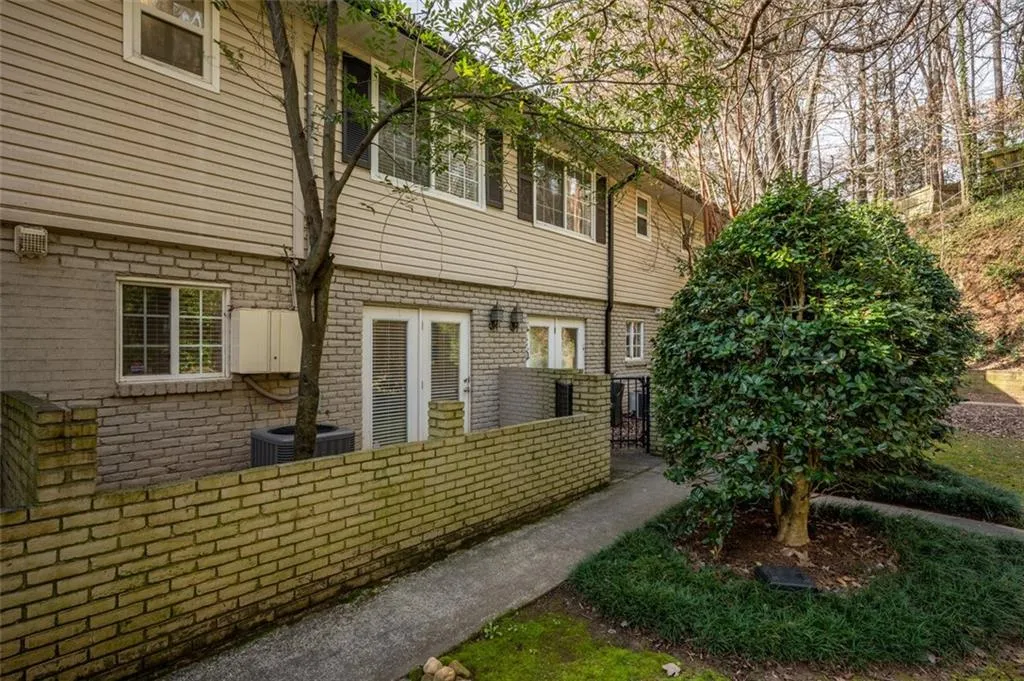View of side of property featuring brick siding and a cooling unit