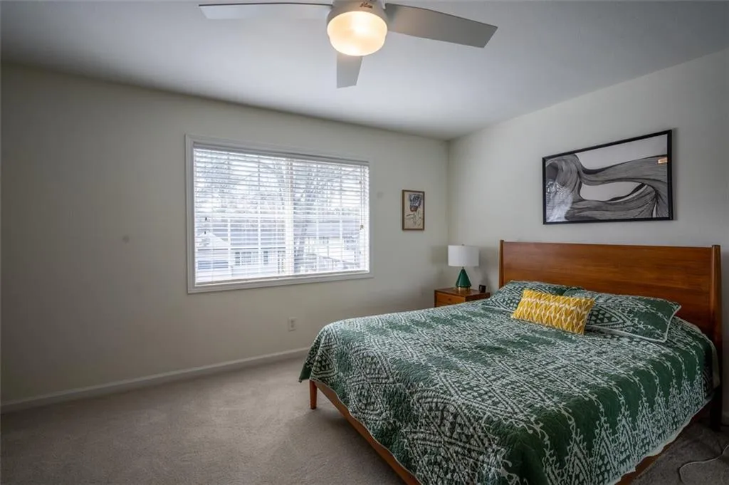 Carpeted bedroom featuring baseboards and ceiling fan