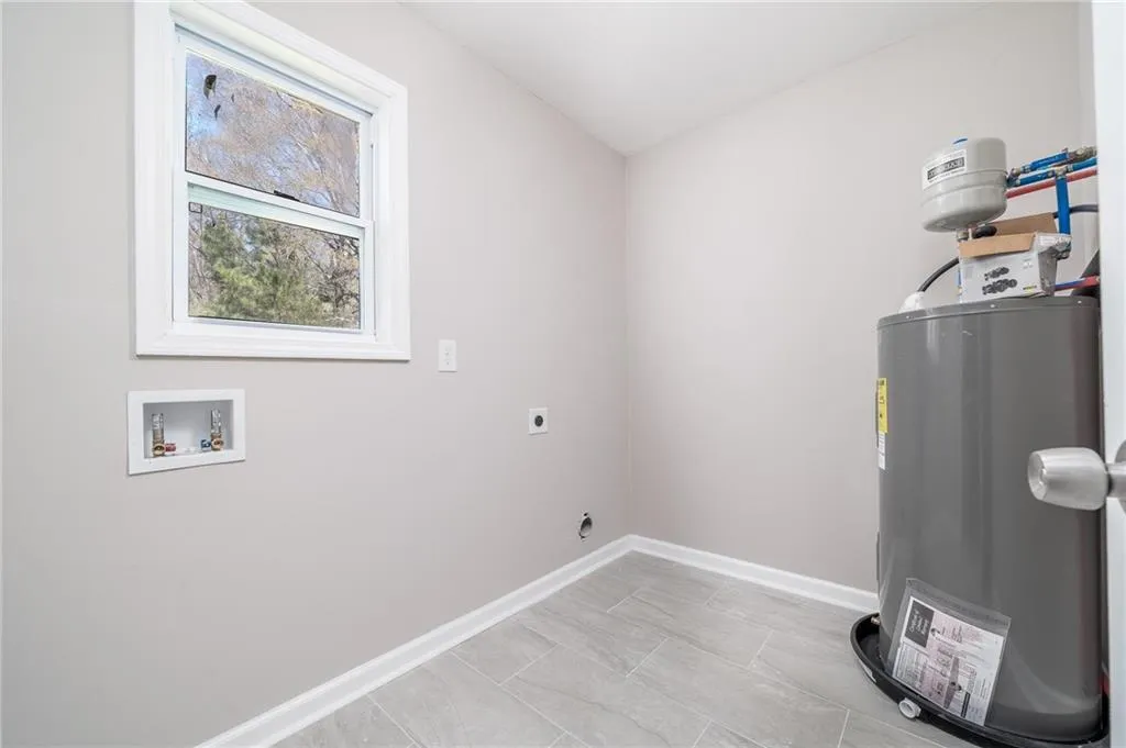 Laundry room with washer hookup, baseboards, laundry area, hookup for an electric dryer, and electric water heater